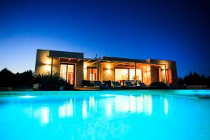 - une grande piscine en face d'une maison la nuit dans l'établissement Can Corda Formentera, à Cala Saona