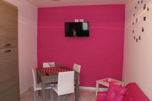 een eetkamer met een roze muur bij casa vacanza EVERY DAY in SantʼAngelo le Fratte