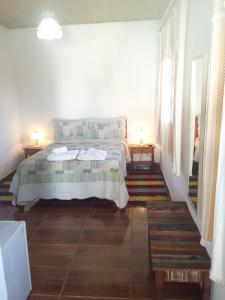 チラデンテスにあるPousada Caminho da Serraのベッドルーム1室(ベッド1台、ナイトスタンド2台付)