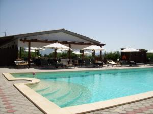 a swimming pool with tables and chairs and umbrellas at Il Vivaio in Tarquinia