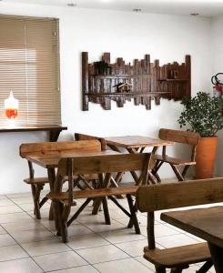 a dining room with wooden tables and benches at Hotel Guaporé - Campo Bom RS in Campo Bom
