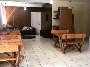 a living room with wooden tables and a couch at Hotel Guaporé - Campo Bom RS in Campo Bom