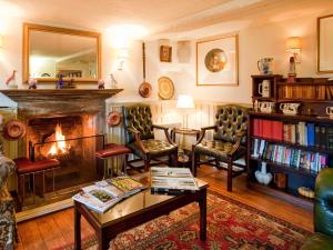 a living room with a fireplace and a table and chairs at The Acorn Inn in Evershot