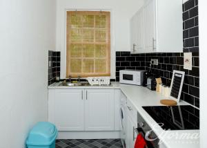 愛丁堡的住宿－Gifford Park Apartment near Edinburgh University - Elforma，厨房配有白色橱柜、水槽和窗户。