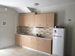 a kitchen with wooden cabinets and a white refrigerator at Il Mondo Apartments in Stavros