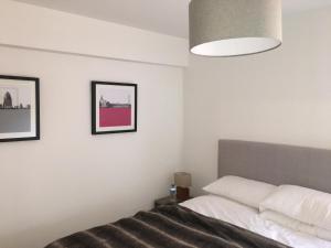 um quarto com uma cama e duas fotografias na parede em Les 4 Elements em Châtel