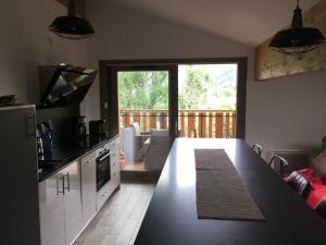 a kitchen with a counter top and a large window at Les 4 Elements in Châtel