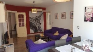 uma sala de estar com sofás roxos em Gran Vía flat em Ceuta