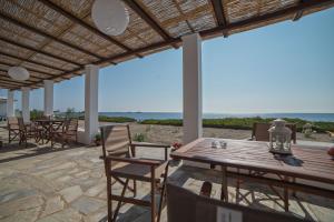 a patio with a table and chairs and the ocean at Aktaia in Skiros