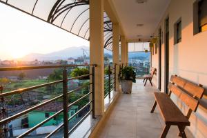 a balcony with a bench and a view of the city at Hospedagem Joanópolis in Joanópolis