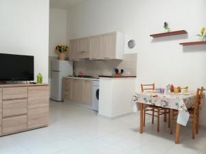 une cuisine avec une table et une télévision. dans l'établissement Casa Eleonora, à Santa Teresa Gallura