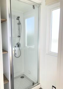 a glass shower in a bathroom with a window at Le Goh Velin in Saint-Gildas-de-Rhuys