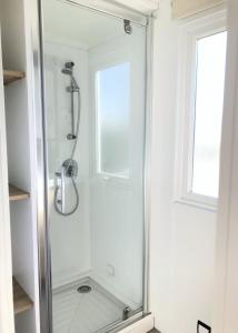 uma cabina de duche em vidro numa casa de banho com uma janela em Le Goh Velin em Saint-Gildas-de-Rhuys