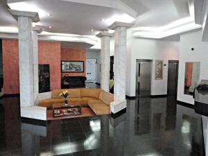 a large living room with a couch and columns at Pekin Palace Hotel in Araçatuba