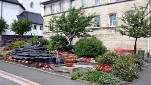 a fountain in a garden in front of a building at Hotel Post in Nordhalben