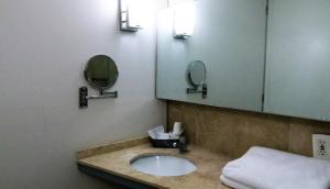 a bathroom with a sink and two mirrors at Aristos Express CDMX in Mexico City