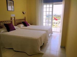 two beds in a hotel room with a window at Hotel Bonaire in Revolta