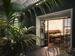 um quarto com mesa, cadeiras e plantas em Niki Athens Hotel em Atenas