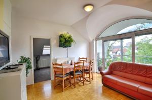 un soggiorno con divano rosso e tavolo di Apartments GreenSLO a Lubiana