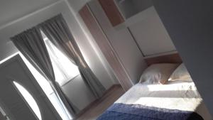 a small bedroom with a bed and a window at Apartments Nives in Mali Lošinj