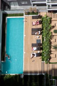 un gruppo di persone sdraiate sulle sedie accanto alla piscina di Urbano Apartments Miraflores Pardo a Lima