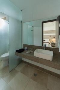 a bathroom with a sink and a toilet and a mirror at Hotel Barranquilla Plaza in Barranquilla