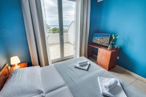 a bedroom with a bed and a large window at B&B Galija in Crikvenica