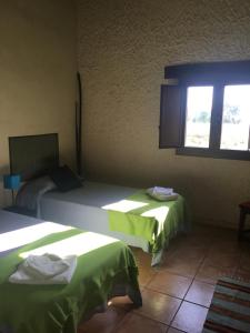 um quarto com 2 camas e uma janela em LaEstancia em Madrigal de la Vera