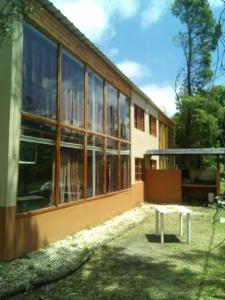 ein Gebäude mit Fenstern und einer Bank davor in der Unterkunft Cabañas Paraiso Duplex 7 solo familias in Mar del Plata