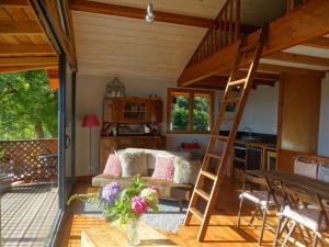 sala de estar con cama elevada y cocina en Gite colombe des bois, en Estadens