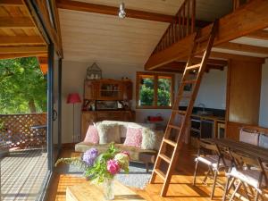 a living room with a loft bed and a kitchen at Gite colombe des bois in Estadens