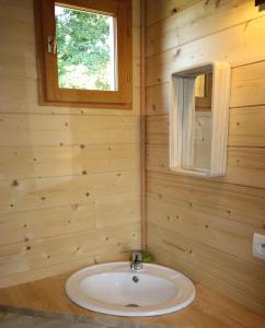 Saint-Antoine-de-BreuilhにあるNuits perchées à Laroqueの木製の壁のバスルーム(シンク付)