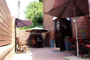 a patio with chairs and tables with umbrellas at Stacja Grand in Szczecin