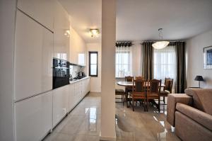 a kitchen and living room with a couch and a table at Poduszka Apartamenty Zdrojowe in Nałęczów