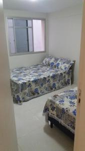 1 Schlafzimmer mit 2 Betten und einem Fenster in der Unterkunft Apartamento Ed. Ouro Preto Praia do Morro in Guarapari