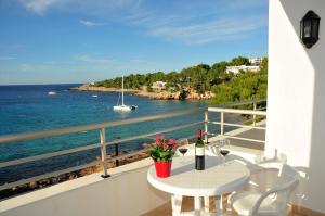 a balcony with a table and a view of the ocean at S'Arenal Apartments in Portinatx