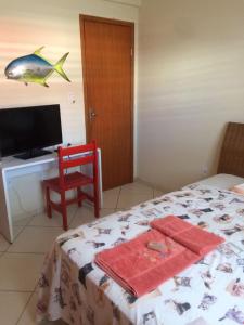sypialnia z łóżkiem i biurkiem z rybą na ścianie w obiekcie Casa da Jussara w mieście Itaperuna