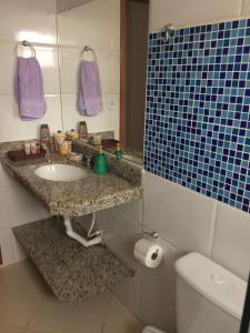 Casa da Jussara في إيتابيرونا: حمام مع حوض ومرآة ومرحاض