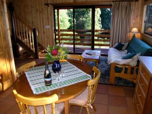 Sala de estar con mesa y botella de vino en Carinya Park, en Gembrook