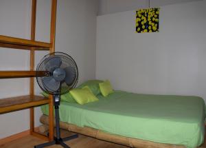 a bedroom with a fan next to a bed at La Pachamama in Máncora