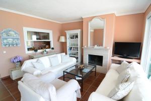 Villa Blue في سكالا بوتامياس: غرفة معيشة مع أرائك بيضاء ومدفأة