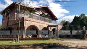 uma casa com uma cerca em frente em Apart y Suite Portal del Luz em Mina Clavero