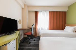 a hotel room with a television and a bed at the b ikebukuro in Tokyo