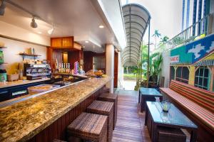 a restaurant with a bar with benches and a counter at The Equus in Honolulu