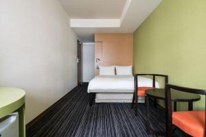 a small room with a bed and two chairs at the b ikebukuro in Tokyo