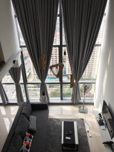 a living room with a couch and a large window at Ginger8 @ Pinnacle PJ in Petaling Jaya