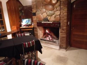 Habitación con chimenea y mesa. en La Magdalena en Mendoza