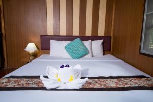a hotel room with a bed with a flower on it at Tontarn Resort & Spa in Khanom