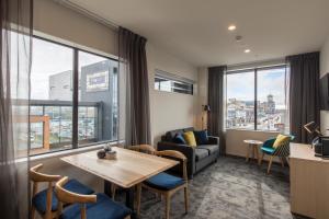 a living room with a couch and a table and chairs at Quest on Manchester Serviced Apartments in Christchurch