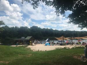 a beach with tables and umbrellas and a body of water at Private Mountain Condo in Wintergreen